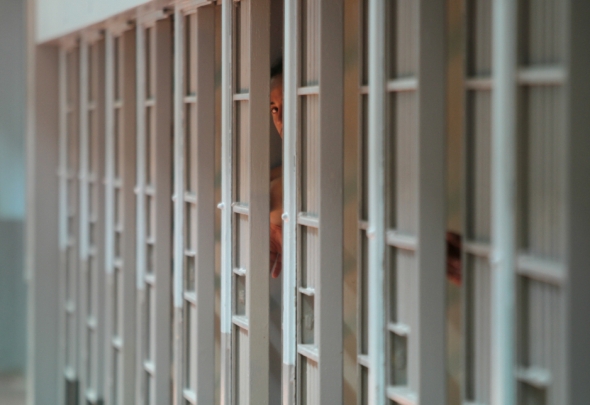 An inmate peeks out of his prison cell at MCI-Cedar Junction at Walpole, Mass. MCI-Cedar Junction is the maximum security reception center for male offenders in Massachusetts. At the center, prisoners are classified for placement in a maximum, medium, or minimum security prison based on their crime and behavior.